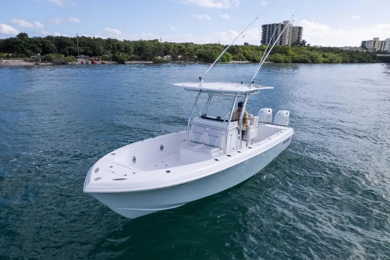 Slide: The Image of 2024 Bluewater 2550 boat on calm water, surrounded by lush greenery and distant buildings. - 8