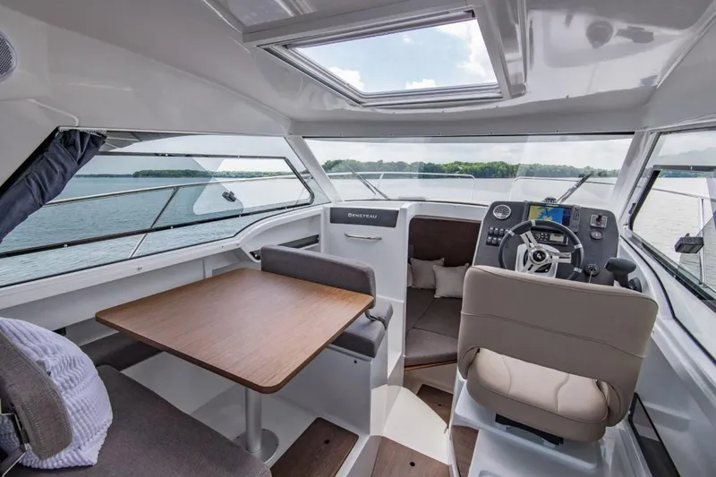 Slide: The Image of 2024 Beneteau America Antares 8 interior with helm, seating, and dining table. - 4