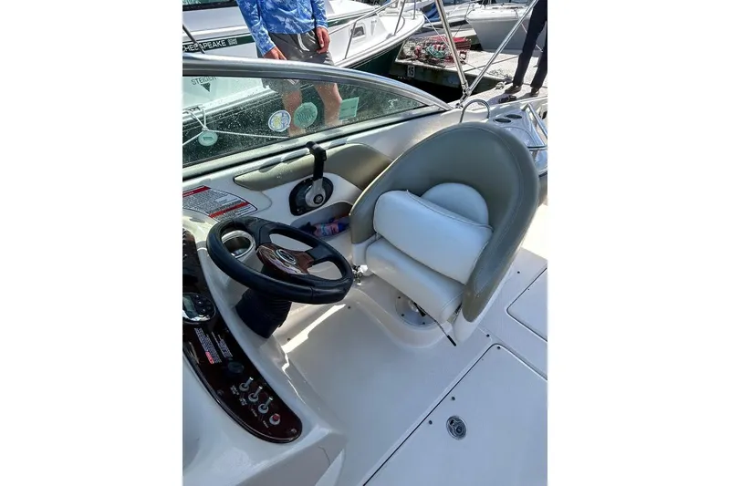 Slide: The Image of 2006 Sea Ray 240 Sundeck helm with steering wheel and comfortable seating. - 7