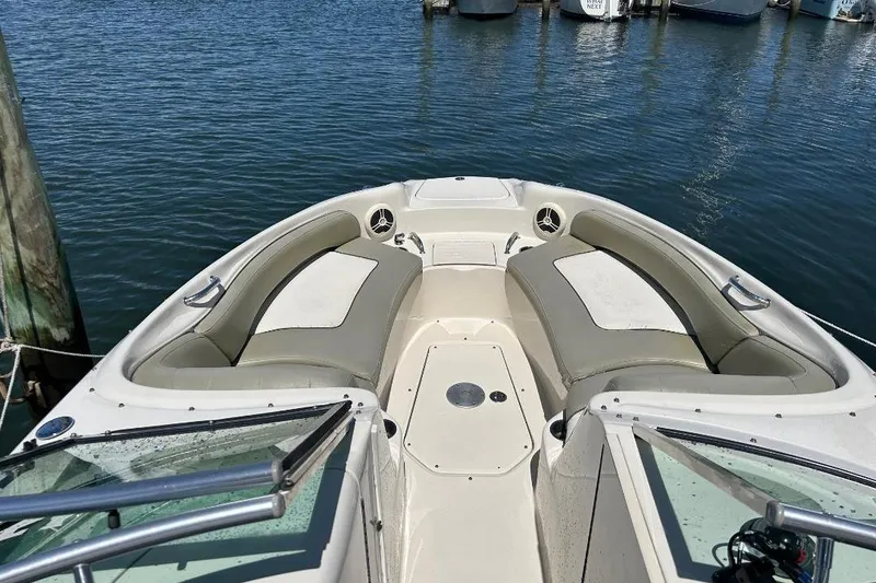 Slide: The Image of 2006 Sea Ray 240 Sundeck boat interior with spacious seating, docked on calm water. - 9
