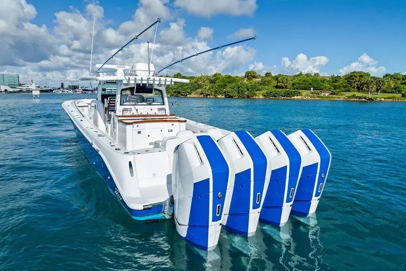 Slide: The Image of 2025 HCB 53 Suenos RXV boat with four powerful outboard engines on clear blue water. - 11