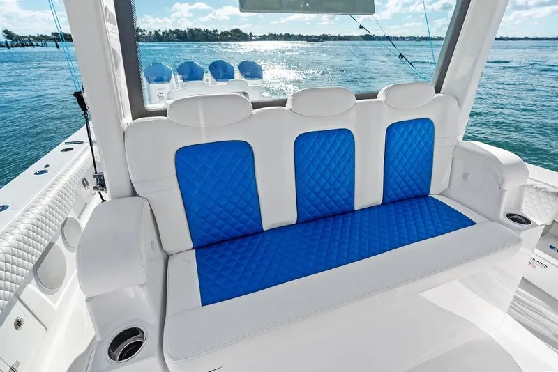 Slide: The Image of 2025 HCB 53 Suenos RXV boat interior with blue and white seating, ocean view. - 23