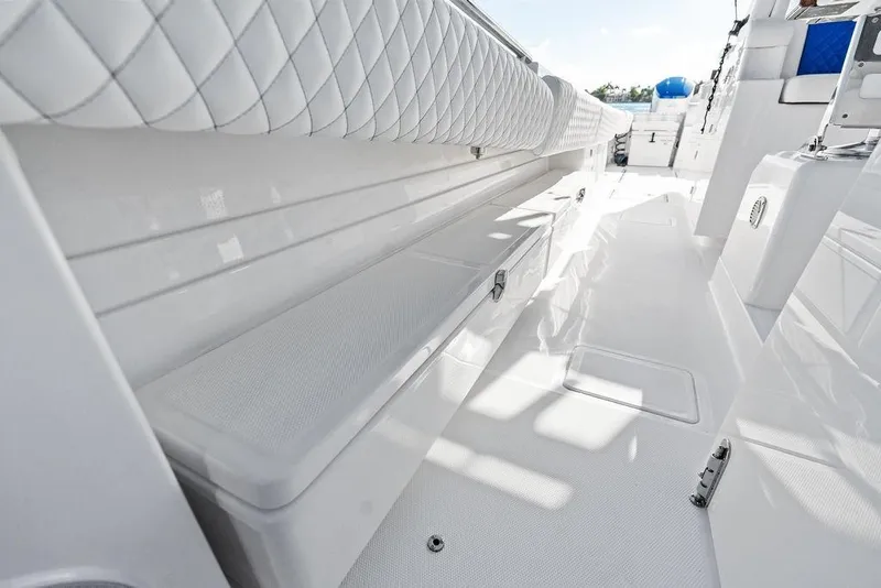 Slide: The Image of 2025 HCB 53 Suenos RXV boat interior with sleek white seating and storage. - 28