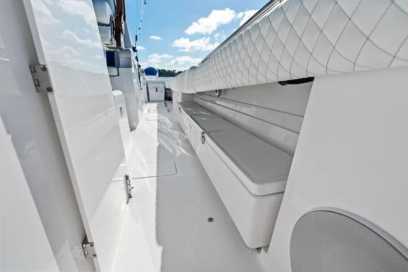 Slide: The Image of 2025 HCB 53 Suenos RXV boat interior with sleek white seating and storage. - 29