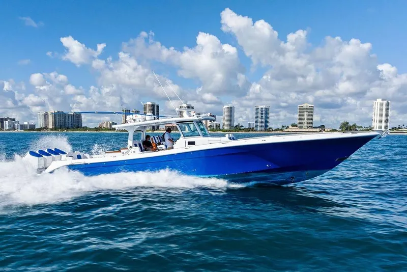 Slide: The Image of 2025 HCB 53 Suenos RXV cruising on blue ocean with city skyline backdrop. - 3