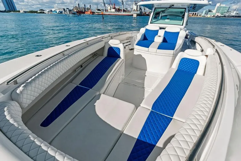 Slide: The Image of 2025 HCB 53 Suenos RXV luxury boat with blue and white seating on open water. - 34