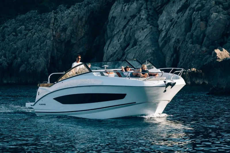 Slide: The Image of 2024 Beneteau Flyer 10 cruising near rocky coastline. - 2