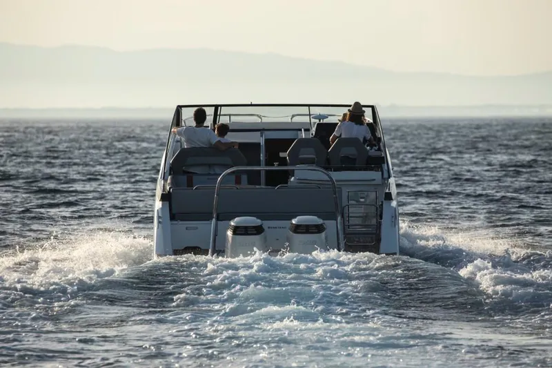 Slide: The Image of 2024 Beneteau Flyer 10 cruising on open water, rear view. - 7