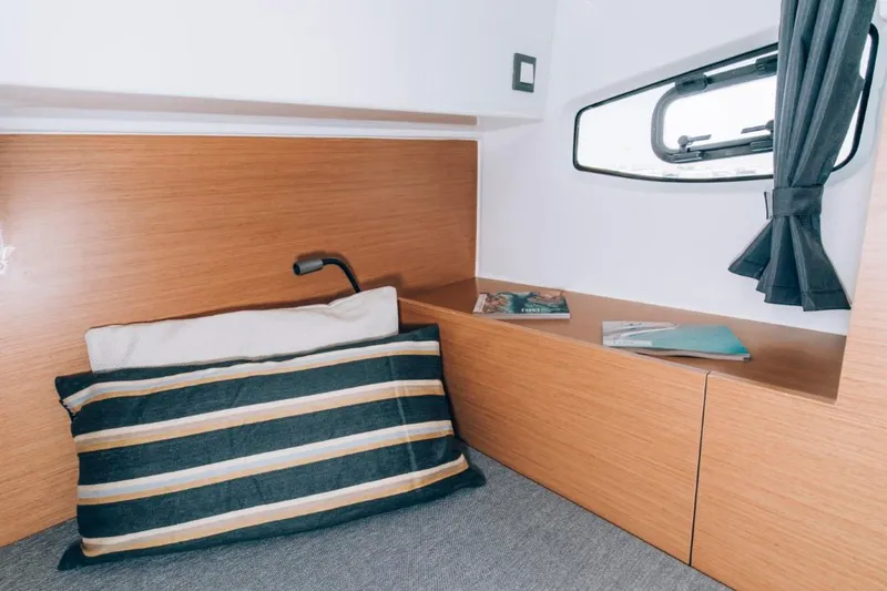 Slide: The Image of 2024 Beneteau Flyer 10 cabin interior with striped pillow and window. - 42