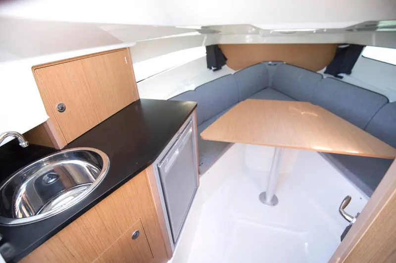 Slide: The Image of 2025 Beneteau Flyer 8 SUNdeck interior with kitchenette and seating area. - 16