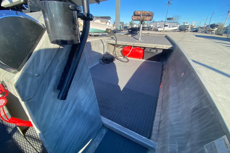 Slide: The Image of 2018 Gator Tail 17' boat interior with seating and equipment, parked outdoors. - 17