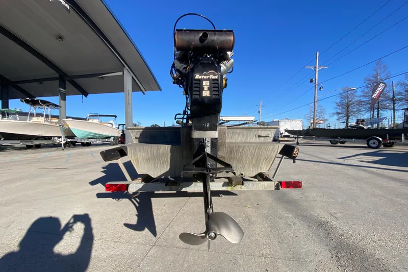 Slide: The Image of 2018 Gator Tail 17' boat with motor, parked outdoors under clear blue sky. - 4