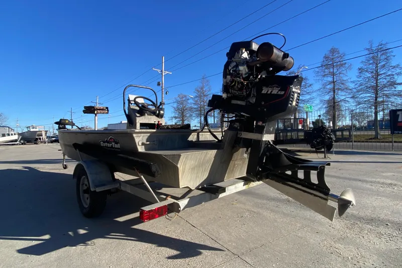 Slide: The Image of 2018 Gator Tail 17' boat on trailer, parked outdoors under clear blue sky. - 5