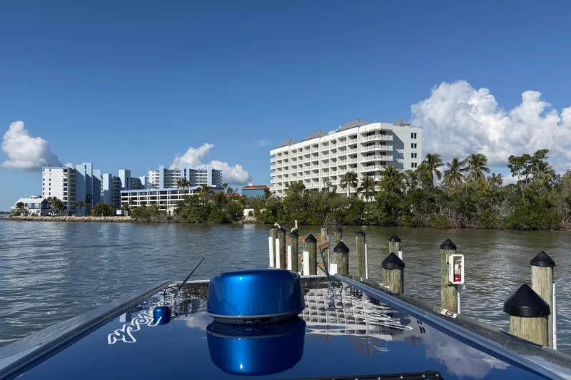 Slide: The Image of 2026 Nor-Tech 390 Sport Center Console docked near waterfront buildings and palm trees. - 47