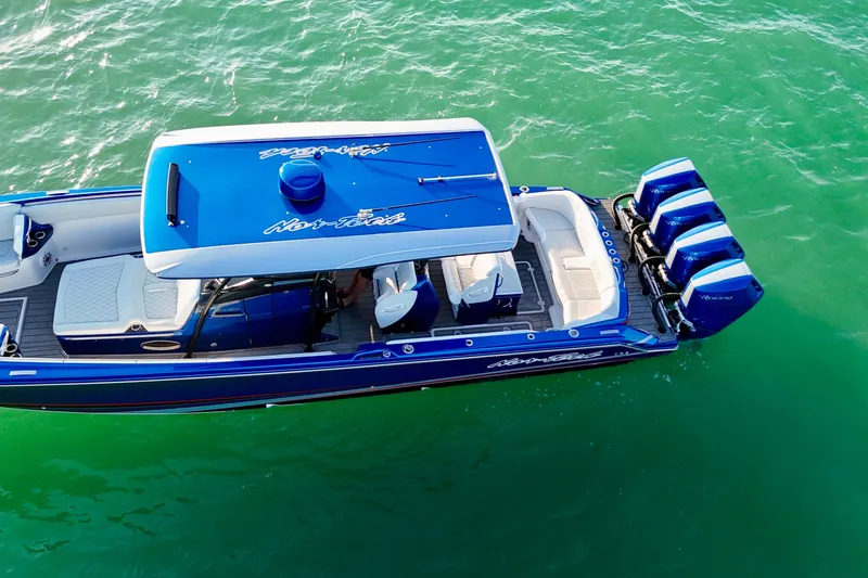 Slide: The Image of 2026 Nor-Tech 390 Sport Center Console boat on turquoise water, featuring triple outboard engines. - 9