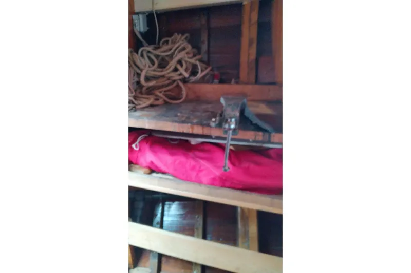 Slide: The Image of Workshop shelf with coiled rope, red fabric, and a vise on a Custom Mayflower 50, 2012. - 16