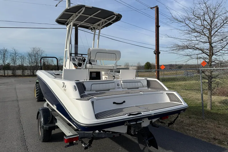 Slide: The Image of 2017 Yamaha Boats 190 FSH Sport on trailer, parked outdoors, rear view. - 4