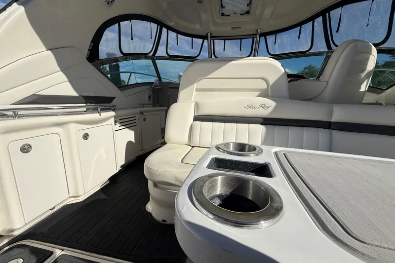 Slide: The Image of Interior of 2005 Sea Ray 390 Sundancer yacht with white seating and cup holders. - 13