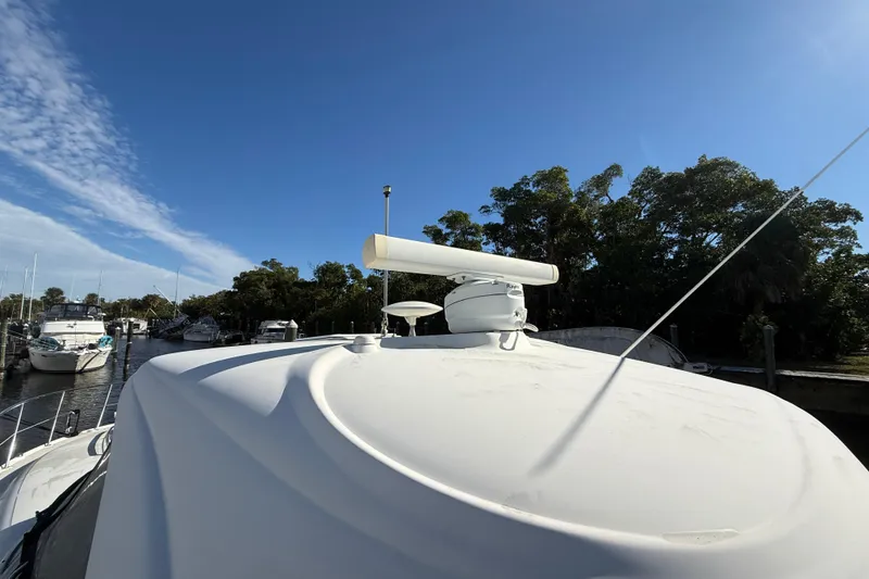 Slide: The Image of 2005 Sea Ray 390 Sundancer yacht with radar, docked near trees and other boats. - 14