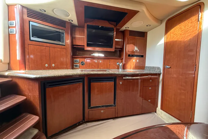 Slide: The Image of Luxurious 2005 Sea Ray 390 Sundancer yacht interior with wood cabinetry and modern amenities. - 19