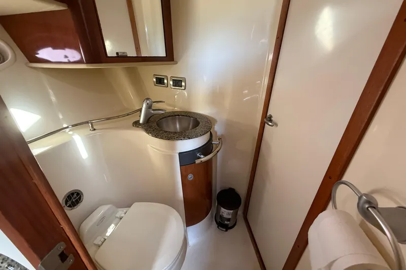 Slide: The Image of 2005 Sea Ray 390 Sundancer bathroom with sink, toilet, and wooden accents. - 22