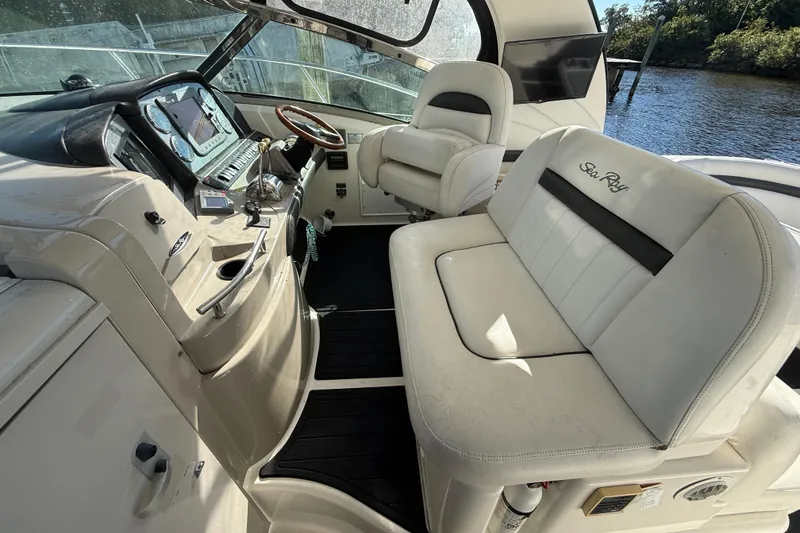 Slide: The Image of 2005 Sea Ray 390 Sundancer cockpit with white seating and control panel. - 8