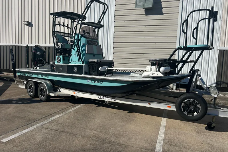 Slide: The Image of 2021 Shallow Stalker Cat 240 Pro Elite boat on trailer, parked outside a building. - 4