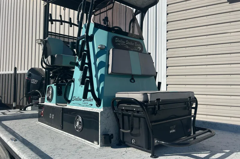 Slide: The Image of 2021 Shallow Stalker Cat 240 Pro Elite boat, teal and gray, docked near a building. - 6