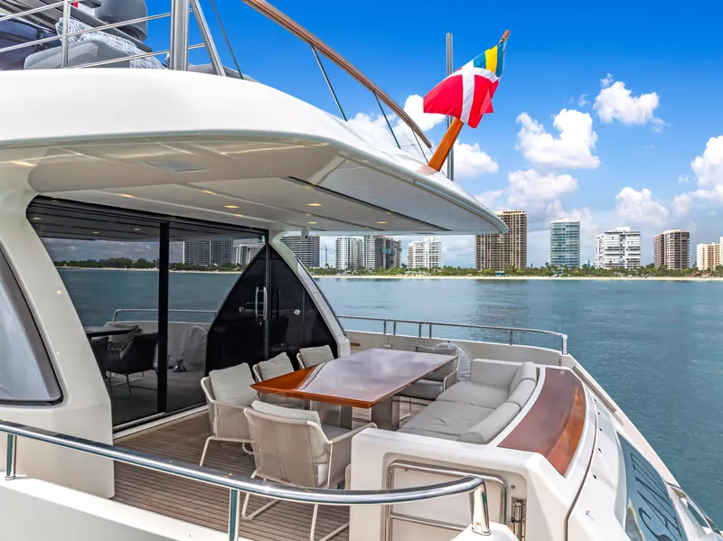 Slide: The Image of Luxurious 2018 Sanlorenzo SL78 yacht with elegant outdoor seating, ocean view, and city skyline backdrop. - 3