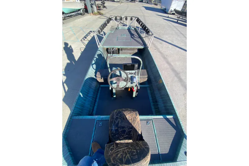 Slide: The Image of 2015 Gator Tail 18' boat interior with steering console and camo seats. - 15