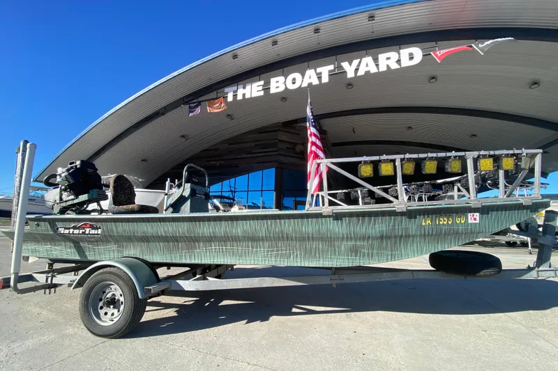 Slide: The Image of 2015 Gator Tail 18' boat on trailer at The Boat Yard, featuring American flag. - 3