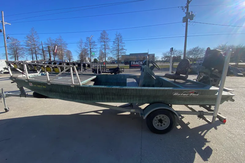 Slide: The Image of 2015 Gator Tail 18' boat on trailer, parked outdoors under clear blue sky. - 7