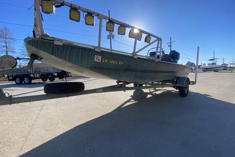 Slide: The Image of 2015 Gator Tail 18' boat on trailer with mounted lights, parked outdoors. - 8