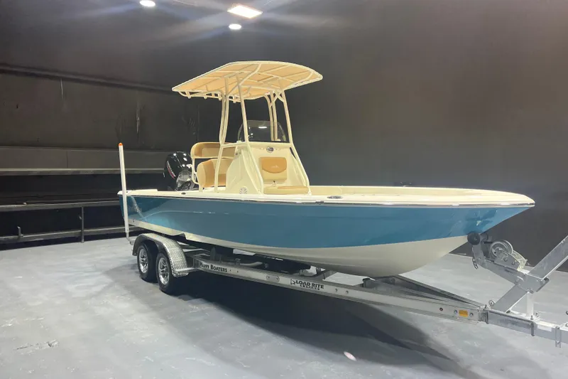 The Image of 2023 NauticStar 227 XTS boat on trailer in indoor setting. - 1