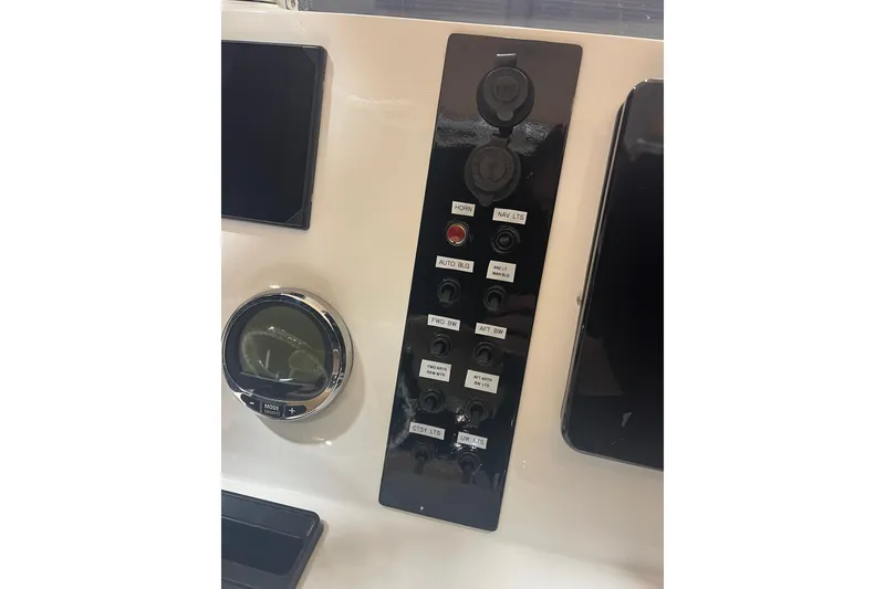 Slide: The Image of 2023 NauticStar 227 XTS boat dashboard with control panel and gauges. - 12