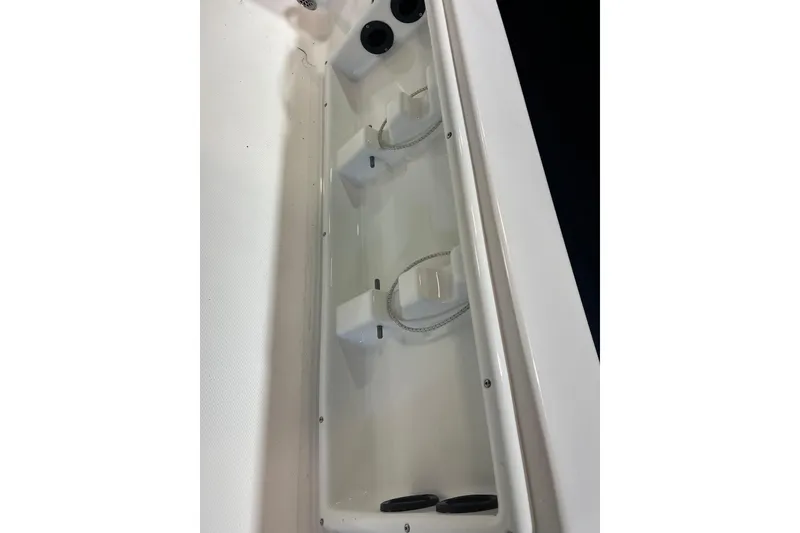 Slide: The Image of 2023 NauticStar 227 XTS boat storage compartment with rod holders. - 20