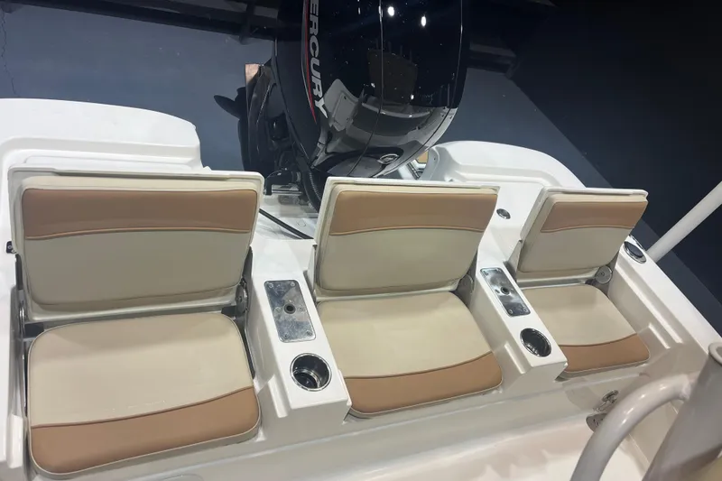 Slide: The Image of 2023 NauticStar 227 XTS boat seats with beige cushions and Mercury engine. - 9