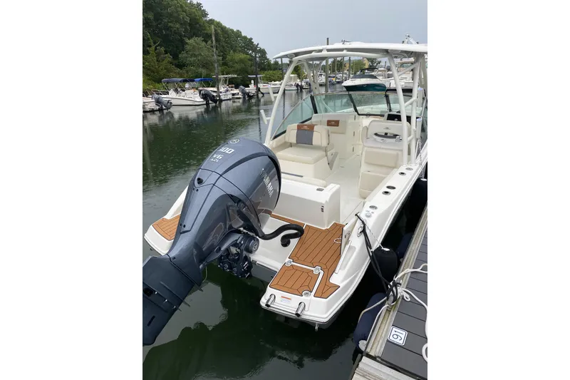 Slide: The Image of 2022 Cobia 240 Dual Console boat docked with Yamaha outboard motor. - 3