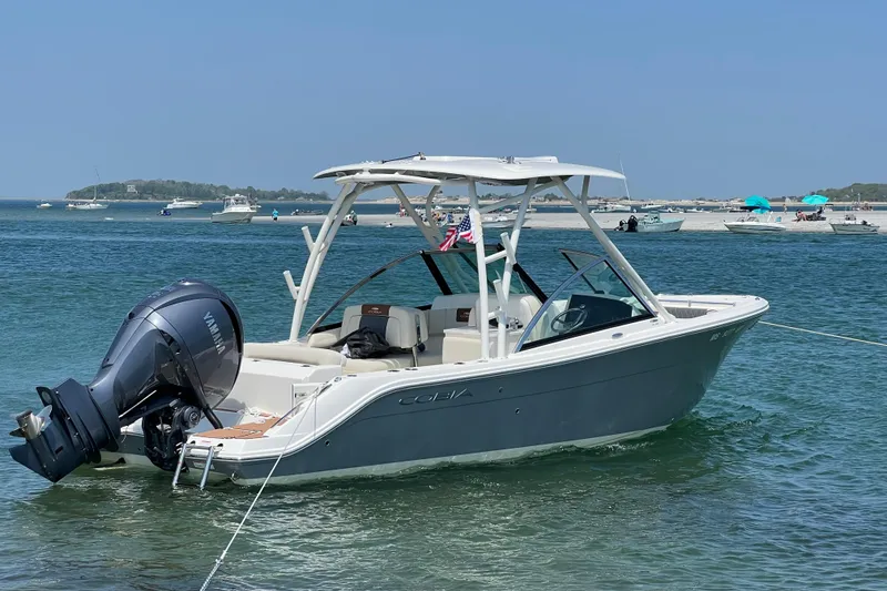 Slide: The Image of 2022 Cobia 240 Dual Console boat anchored in clear blue water, featuring a Yamaha outboard motor. - 9