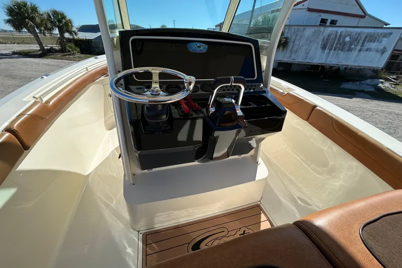 Slide: The Image of 2016 Scout 275 LXF boat helm with steering wheel and controls. - 10