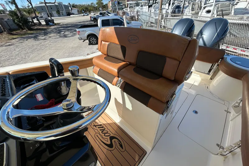 Slide: The Image of 2016 Scout 275 LXF boat interior with leather seating and chrome steering wheel. - 12
