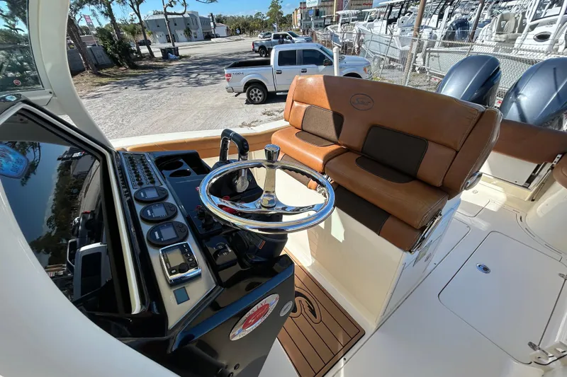 Slide: The Image of 2016 Scout 275 LXF boat interior with steering wheel and leather seating. - 13