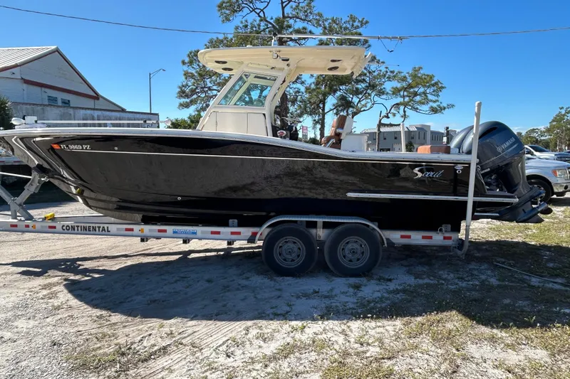 Slide: The Image of 2016 Scout 275 LXF boat on trailer, parked outdoors, side view. - 23
