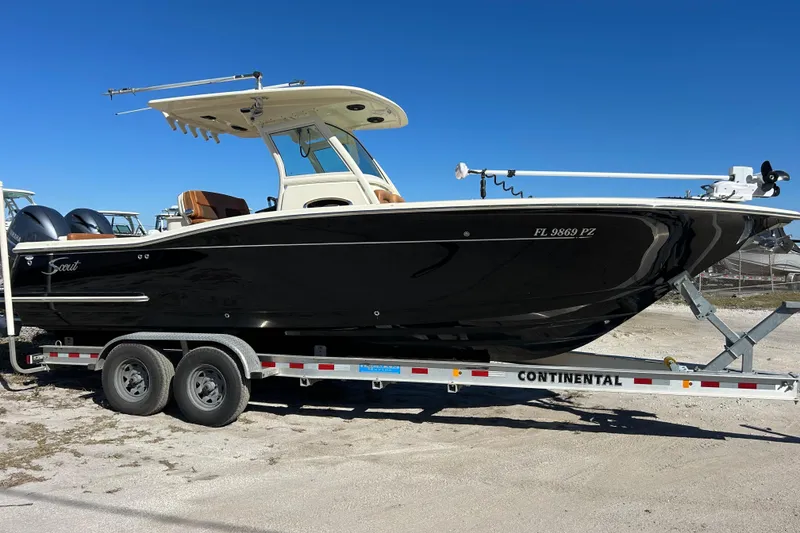 Slide: The Image of 2016 Scout 275 LXF boat on trailer under clear blue sky. - 5