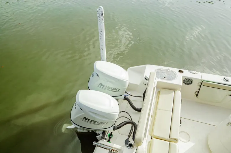 Slide: The Image of 2022 Sea Chaser 24 HFC boat with dual Suzuki outboard motors on calm water. - 17