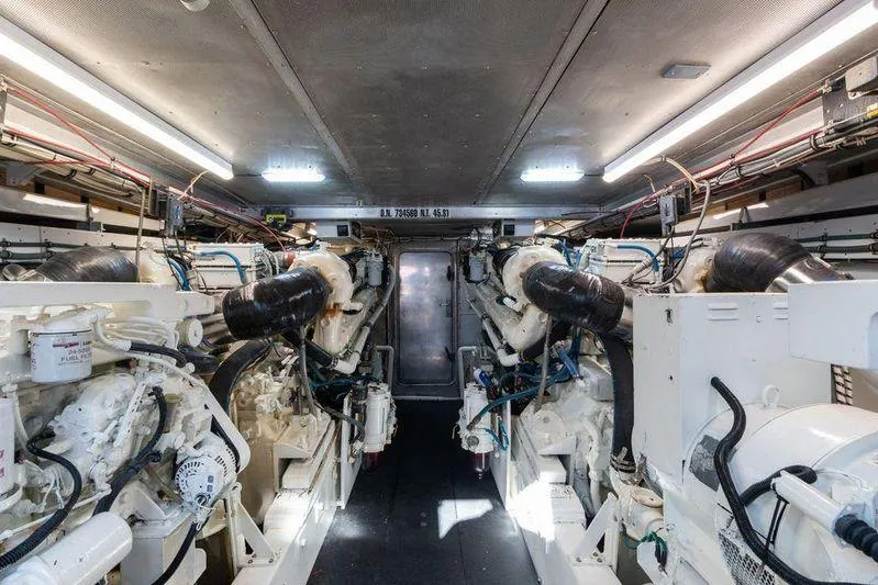 Slide: The Image of Engine room of a 1992 Huckins 70 Convertible yacht, featuring dual engines and modern equipment. - 18