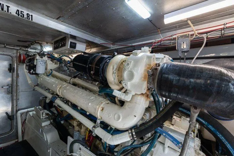 Slide: The Image of Engine room of a 1992 Huckins 70 Convertible yacht, showcasing complex machinery and wiring. - 20