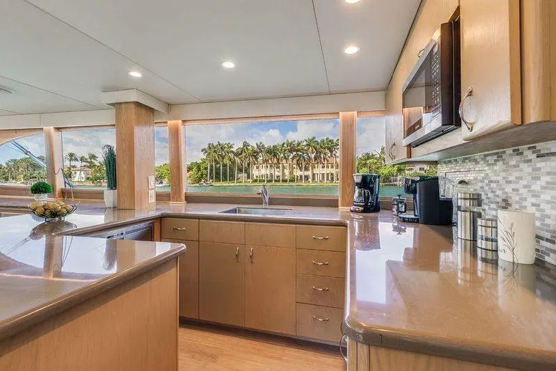 Slide: The Image of Luxurious kitchen interior of 1992 Huckins 70 Convertible yacht with modern appliances and scenic views. - 7