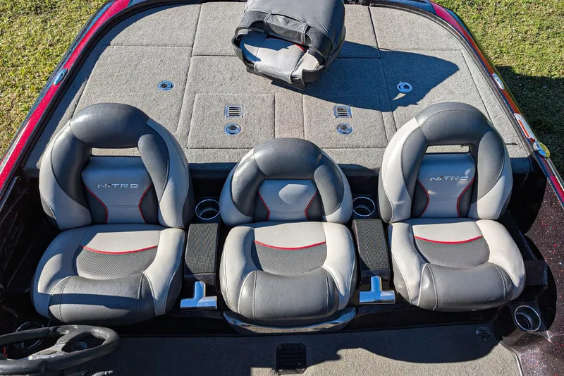 Slide: The Image of 2015 Nitro Z-9 boat interior with three gray and red seats, carpeted deck. - 12