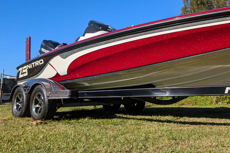 Slide: The Image of 2015 Nitro Z-9 boat on trailer, red and white design, parked on grass. - 3